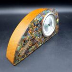 Front view of vintage pāua shell mantel clock with analogue dial