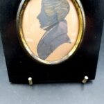 Antique 19th-century ink profile portrait of a gentleman in apparent Regency-style dress with ebonised wood surround